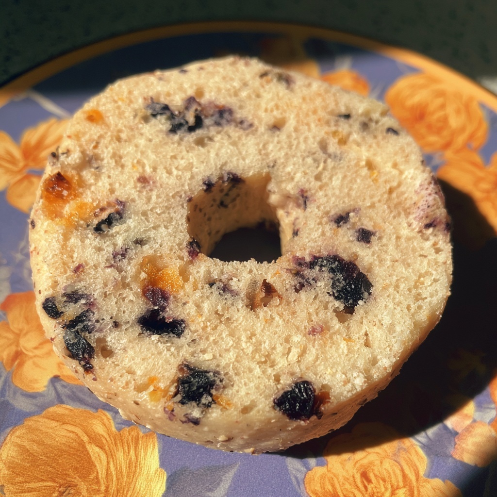 House-made dried fruit and blueberry ring cake on a floral plate in morning sunlight